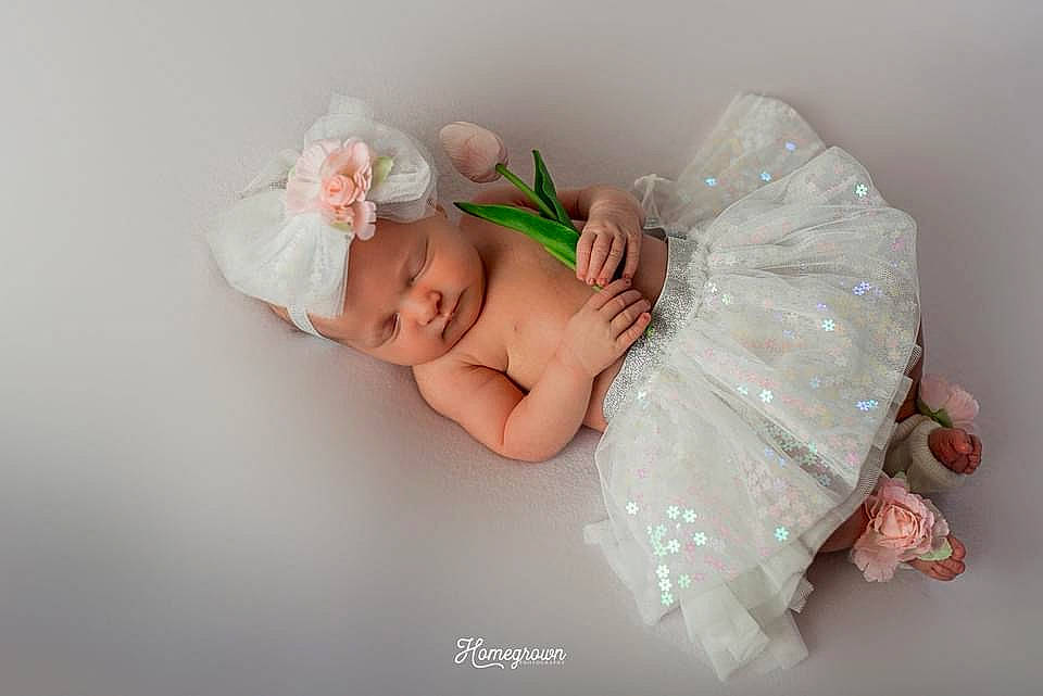 Saige is registered to the contest to win money with this photo: baby, baby_toddler_clothing, bridal_accessory, child, comfort, embellishment, eye, fashion_accessory, flash_photography, hair_accessory, happy, headband, headgear, headpiece, headwear, iris, jewellery, linens, person, petal