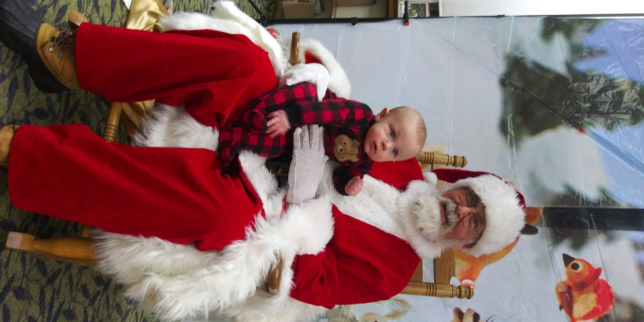 Peyton is registered to the contest to win money with this photo: carmine, christmas, christmas_decoration, christmas_eve, costume_hat, event, fictional_character, fun, fur, fur_clothing, hat, headwear, holiday, lap, person, red, santa_claus, toddler, tradition, tree