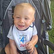 Waylon joined the competition — help win amazing prizes! baby, child, stroller, bib, smiling, happy, outdoor, grass, car_wheel, clothing, face, person, summer, celebration, cute, infant, seat, portrait, sunlight, fun