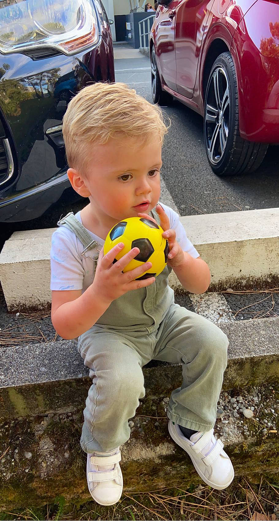 Gabin participe au concours pour gagner de l'argent avec cette photo : automotive_design, automotive_lighting, automotive_tire, car, cool, grass, green, head, motor_vehicle, person, photograph, shoe, sneakers, tire, toddler, toy, vehicle, vehicle_door, wheel, white