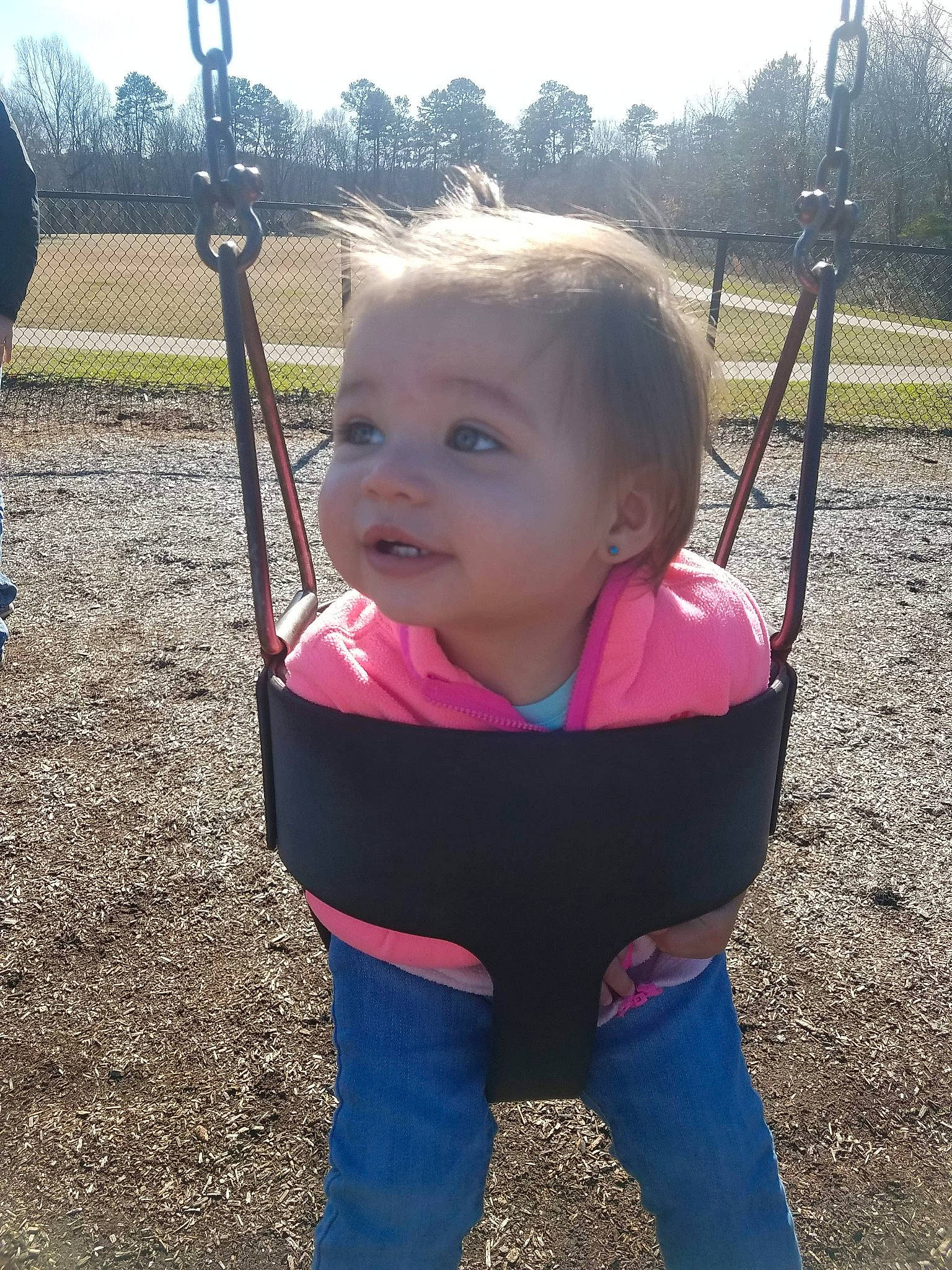 Priya is registered to the contest to win money with this photo: baby, child, city, fun, grass, human_settlement, outdoor_play_equipment, person, pink, plant, play, playground, product, public_space, recreation, skin, sky, smile, swing, toddler