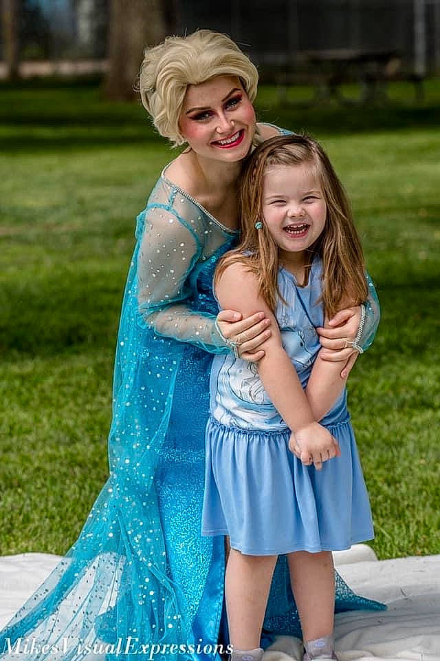 Lilyanna is registered to the contest to win money with this photo: aqua, blond, blue, child, dress, electric_blue, family, formal_wear, fun, grass, happy, headwear, interaction, iris, joy, people, person, photograph, photography, smile