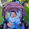 baby, baby_carrier, blue_socks, child, clothing, cute, daylight, grass, happy, infant, nature, outdoor, person, playful, purple, seat_belt, smiling, stroller, sunlight, tree
