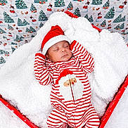 Elias is registered to the contest to win money with this photo: baby, sleeping, christmas, holiday, festive, red_and_white, striped_clothing, santa_hat, cozy, blanket, box, snowman_pattern, christmas_tree, rabbit, squirrel, winter, cute, infant, soft_texture, holiday_decor