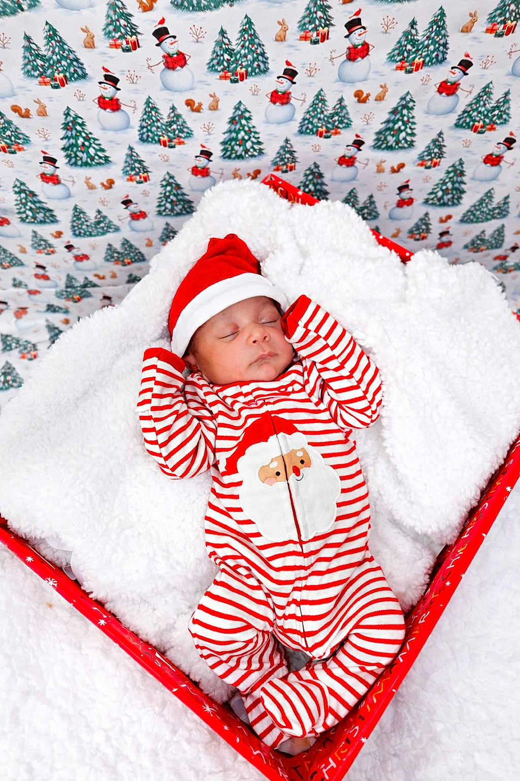 Elias is registered to the contest to win money with this photo: baby, sleeping, christmas, holiday, festive, red_and_white, striped_clothing, santa_hat, cozy, blanket, box, snowman_pattern, christmas_tree, rabbit, squirrel, winter, cute, infant, soft_texture, holiday_decor