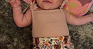 Wrenlee Jade is registered to the contest to win money with this photo: baby, infant, child, playmat, carpet, clothing, floral_shorts, animal_print, cute, lying_down, indoors, soft_texture, curious_expression, pink, beige, person, skin, head, arms, legs