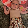 baby, infant, child, playmat, carpet, clothing, floral_shorts, animal_print, cute, lying_down, indoors, soft_texture, curious_expression, pink, beige, person, skin, head, arms, legs