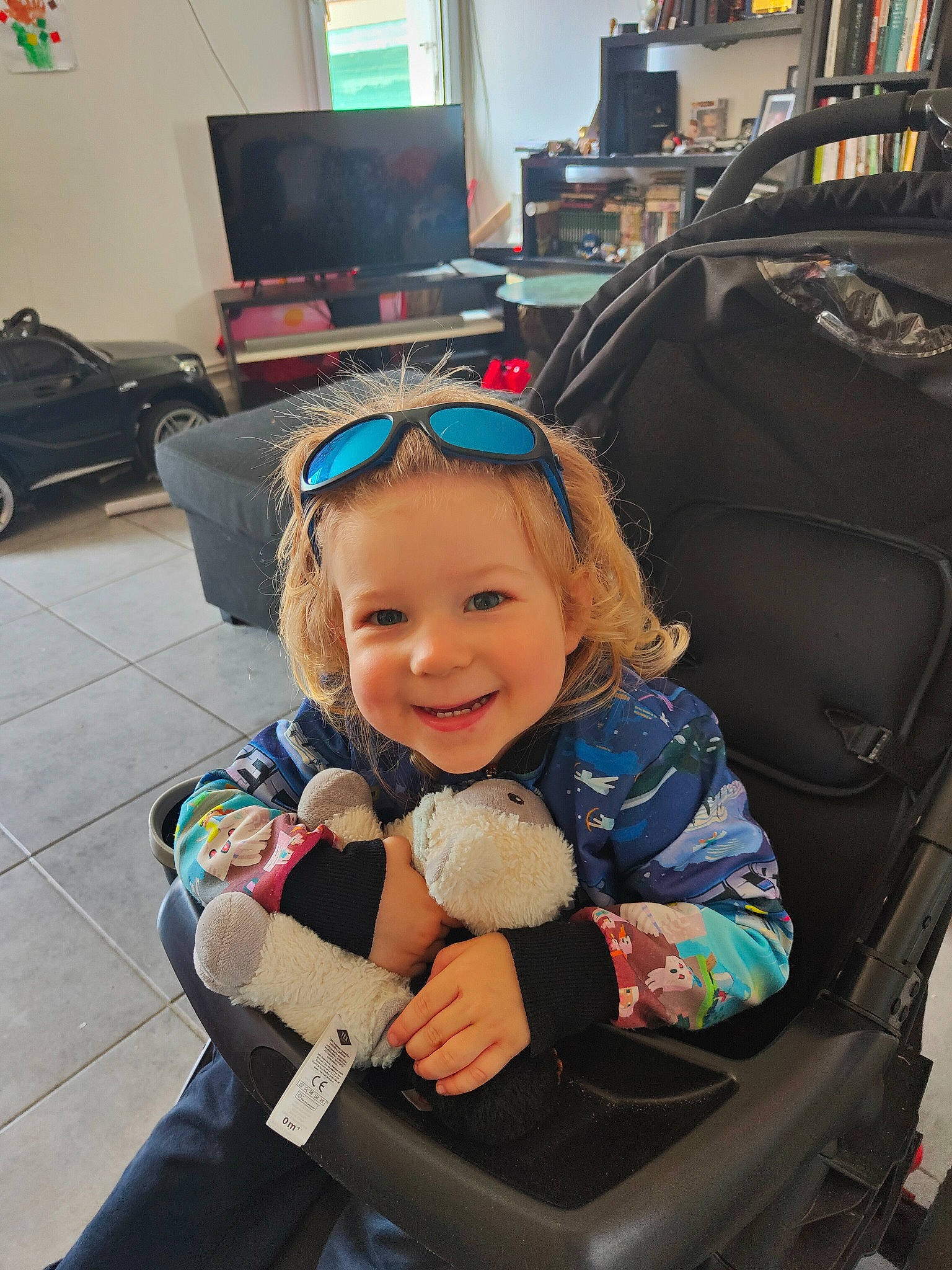 Ezékiel participe au concours pour gagner de l'argent avec cette photo : automotive_design, baby, baby_carriage, child, comfort, computer_keyboard, computer_monitor, desk, eye, fun, headwear, home_appliance, joy, motor_vehicle, person, product, smile, television, television_set, tire