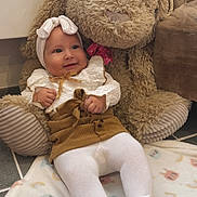 Esmée a rejoint le concours — aidez-le/la à gagner de superbes lots ! baby, baby_clothes, blanket, bunny, child, cute, floor, floor_tiles, happy, headband, indoor, plush, sitting, skirt, smiling, soft_toy, stuffed_animal, tights, toy, white_shoes