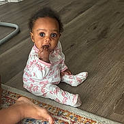 Zendaya joined the competition — help win amazing prizes! baby, child, pajamas, floor, wooden_floor, carpet, rug, foot, hand, curious, indoors, home, person, sitting, sleepwear, infant, cute, looking_at_camera, expression, pink