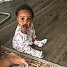 baby, child, pajamas, floor, wooden_floor, carpet, rug, foot, hand, curious, indoors, home, person, sitting, sleepwear, infant, cute, looking_at_camera, expression, pink