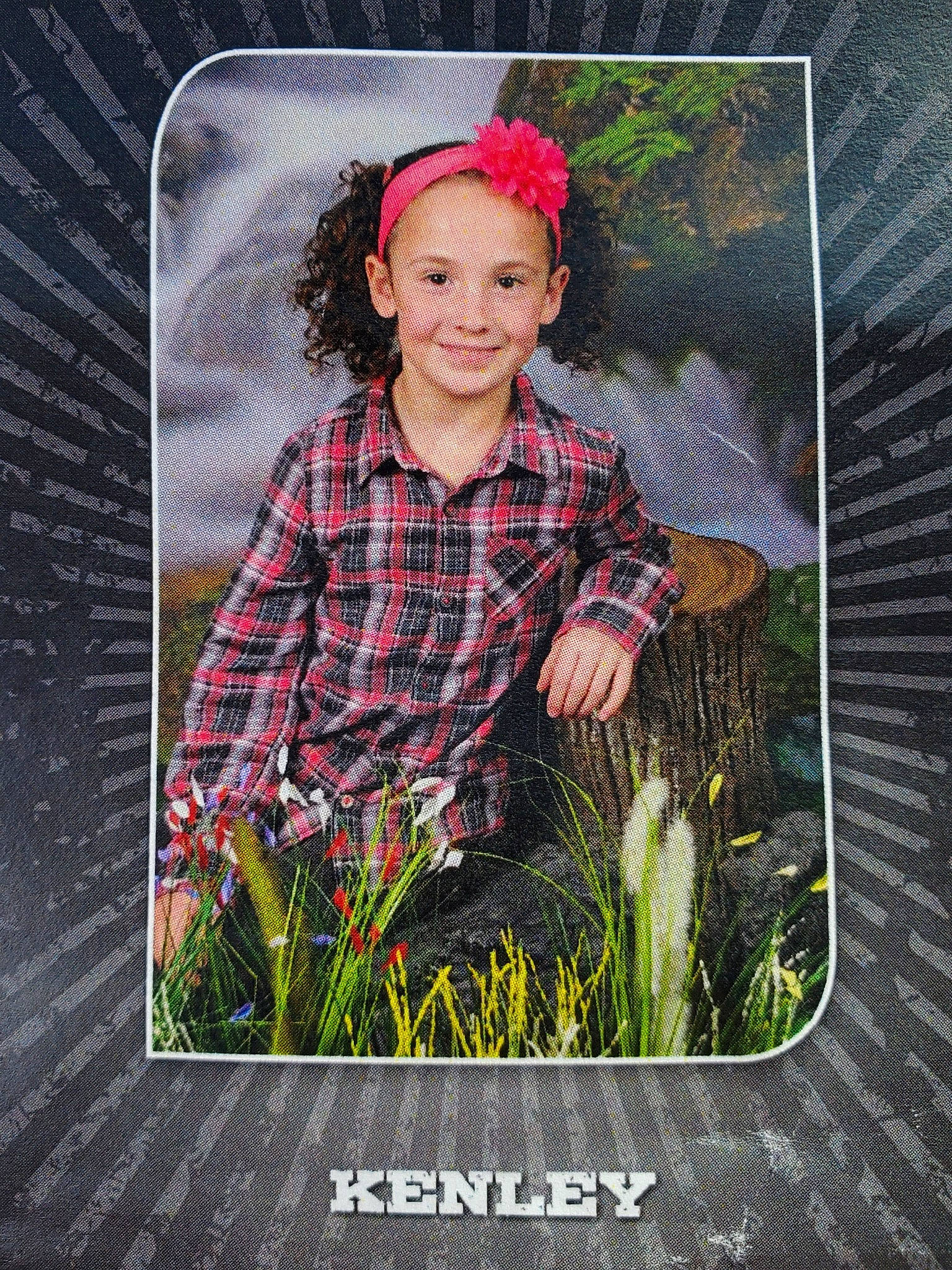 Kenley joined the competition — help win amazing prizes! child, face, facial_expression, flash_photography, flower, font, grass, happy, head, joy, pattern, people_in_nature, person, plaid, plant, product, rectangle, sleeve, smile, stock_photography