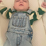 Myles is registered to the contest to win money with this photo: baby, sleeping, denim_overalls, striped_sweater, child, infant, clothing, resting, quilted_surface, toddler, cute, portrait, indoor, peaceful, young_child, hands_up, soft_lighting, closeup, face, head