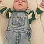baby, sleeping, denim_overalls, striped_sweater, child, infant, clothing, resting, quilted_surface, toddler, cute, portrait, indoor, peaceful, young_child, hands_up, soft_lighting, closeup, face, head