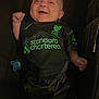 Myles joined the competition — help win amazing prizes! baby, smiling, infant, clothing, football_kit, black, green, lying_down, pacifier, happy, person, indoors, cute, small, shirt, shorts, sportswear, hand, face, pose