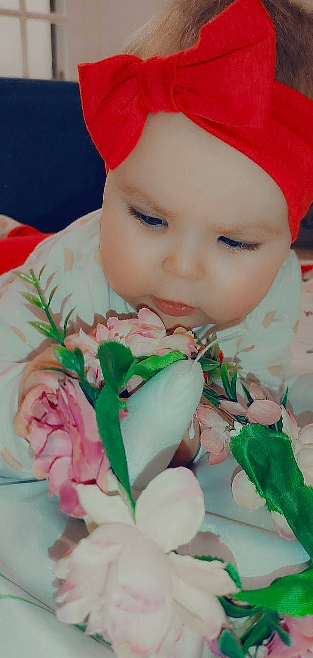 Jannah participe au concours pour gagner de l'argent avec cette photo : baby, baby_toddler_clothing, cap, cheek, child, chin, close_up, eye, face, grass, happy, head, headwear, lip, person, petal, pink, skin, sleeve, textile