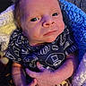 baby, infant, child, portrait, face, wide_eyed, smiling, lying_down, blanket, knitted_blanket, blue, purple_lighting, basketball, sportswear, clothing, hands, adult_hands, cozy, indoor, close_up