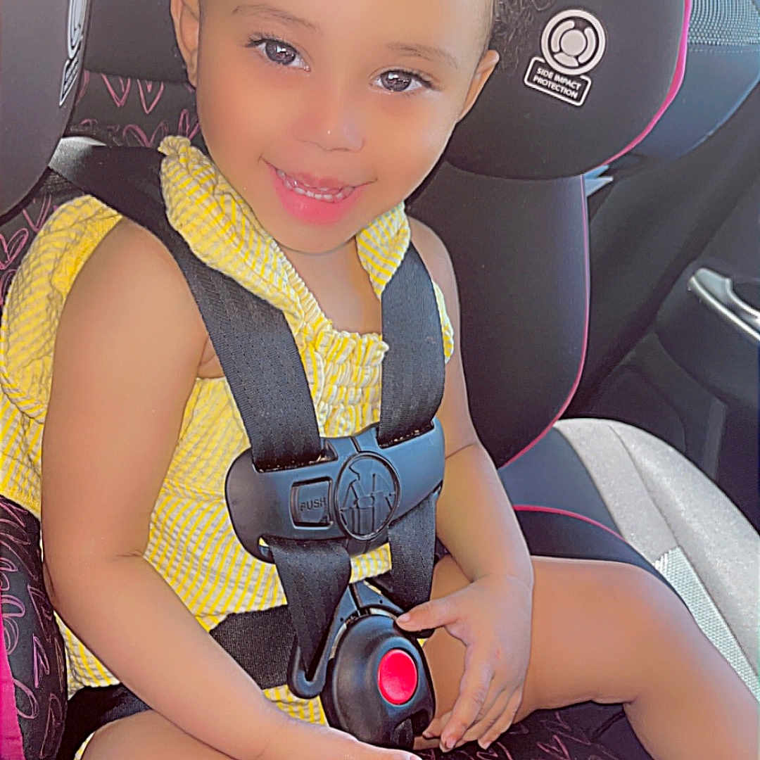 Te'Niyah joined the competition — help win amazing prizes! baby, car_interior, car_seat, child, curly_hair, cute, face, hands, happy, heart_pattern, portrait, safety, seat, seatbelt, smiling, sunlight, toddler, yellow_bow, yellow_clothing, young_child