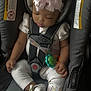 baby, sleeping, car_seat, bow, pink, infant, child, cute, straps, clothing, footwear, bracelet, toy, seatbelt, safety, peaceful, indoors, portrait, closeup, adorable