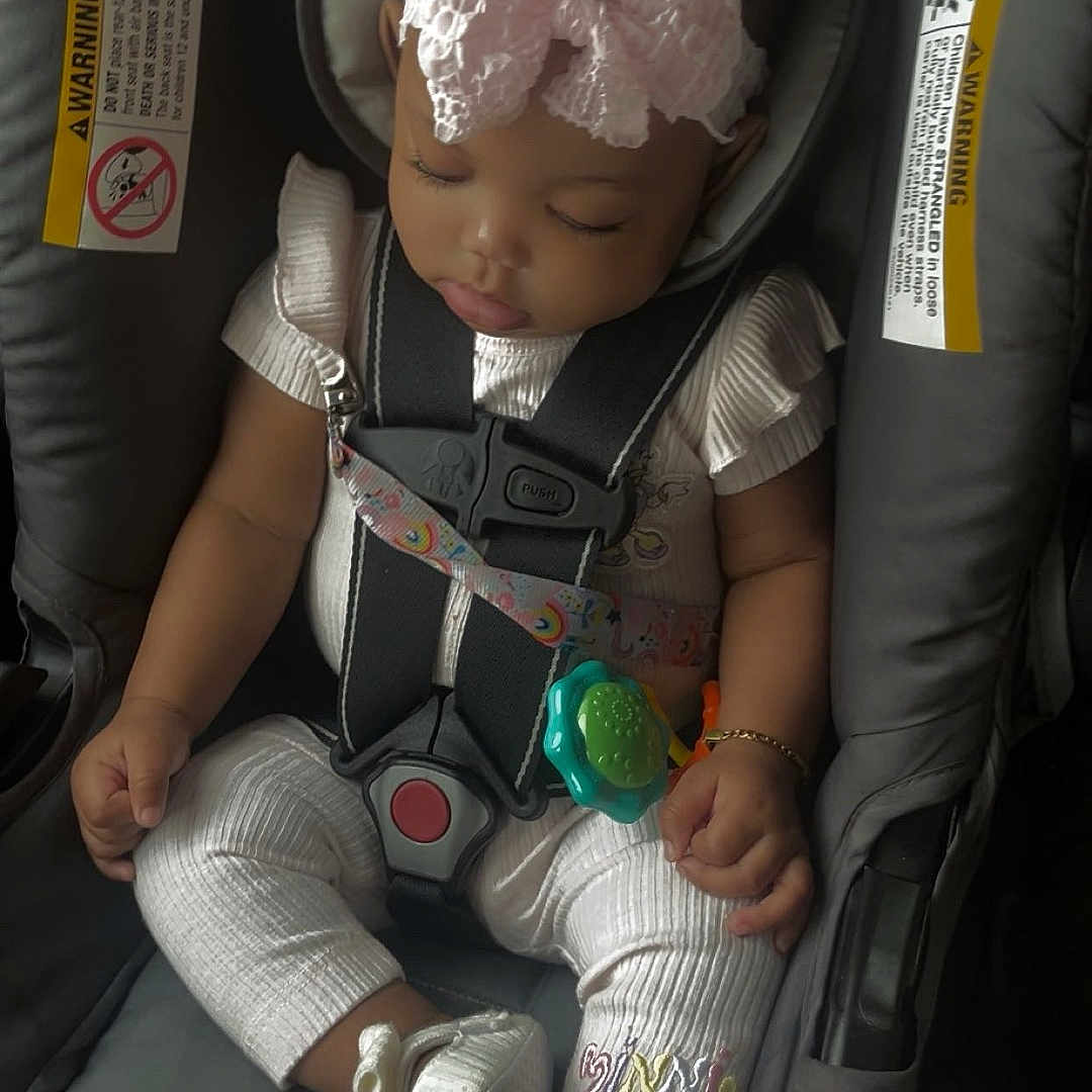 Amira joined the competition — help win amazing prizes! adorable, baby, bow, bracelet, car_seat, child, closeup, clothing, cute, footwear, indoors, infant, peaceful, pink, portrait, safety, seatbelt, sleeping, straps, toy