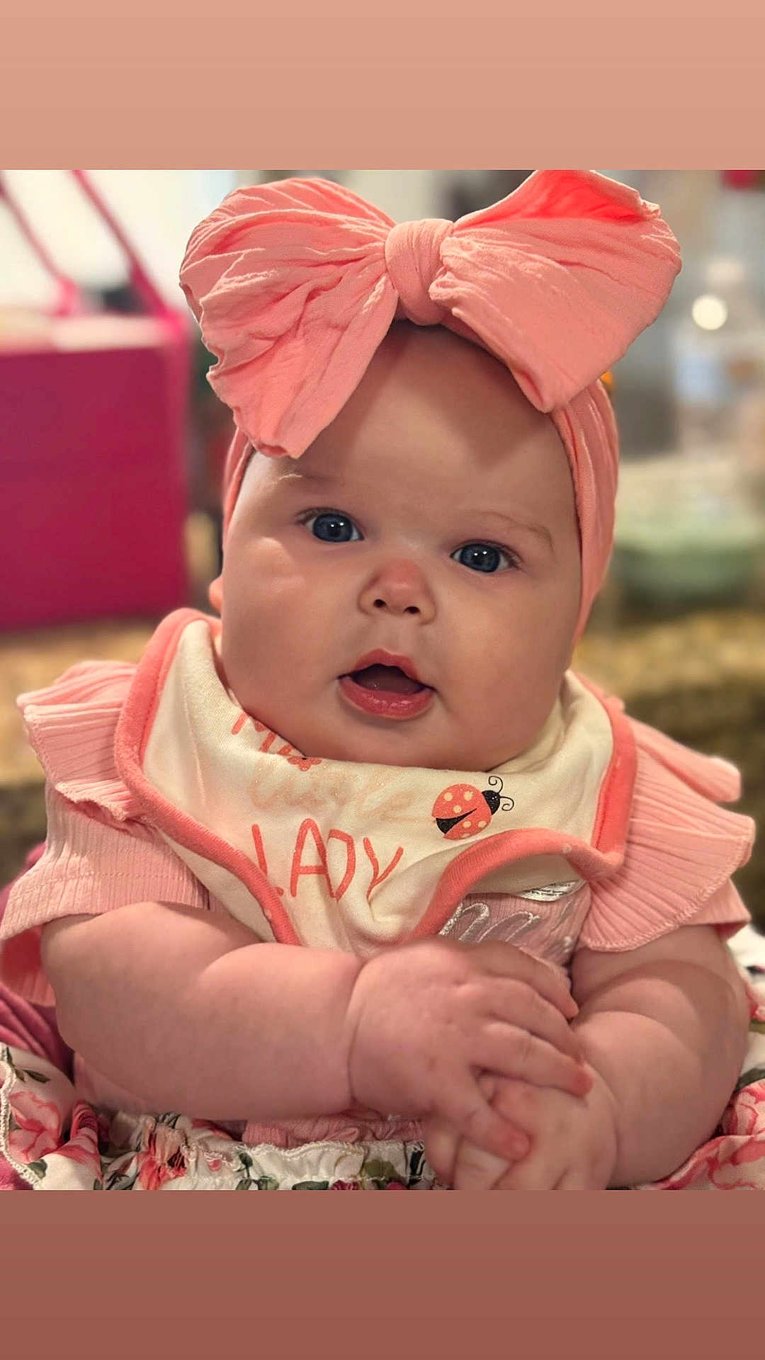 Eliana joined the competition — help win amazing prizes! baby, infant, headband, bow, bib, chubby_cheeks, hands, dress, floral_pattern, pink, portrait, close_up, eyes, mouth, cute, smile, skin, indoor, bokeh, accessory