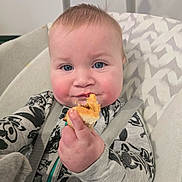 Declyn is registered to the contest to win money with this photo: baby, child, food, bread, high_chair, face, blue_eyes, hand, clothing, pattern, cushion, seatbelt, indoor, cute, portrait, infant, skin, smile, young, person
