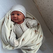 Tommy joined the competition — help win amazing prizes! baby, blanket, crib, hat, infant, sleepwear, star_pattern, soft_texture, cute, child, newborn, lying_down, cozy, bed, pale_colors, indoors, portrait, wrapped, comfortable, sleeping_area