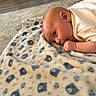 baby, infant, blanket, blue, white, pattern, floor, carpet, hand, face, skin, clothing, sleeve, lying_down, indoors, cute, toddler, child, newborn, soft_texture