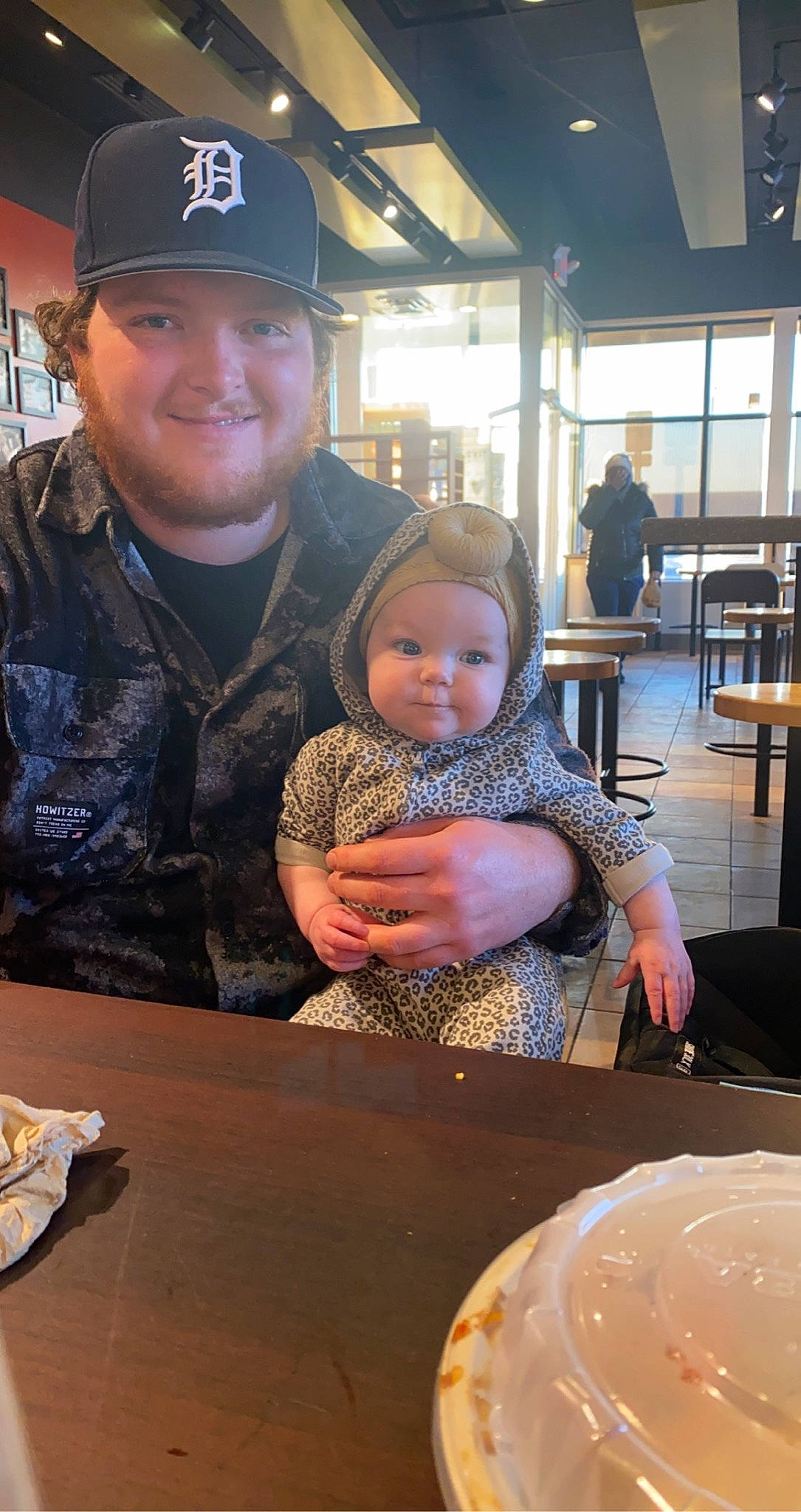 Oaklyn is registered to the contest to win money with this photo: baby, baseball_cap, cap, chair, cup, dish, dishware, drinkware, event, fun, headwear, human, joy, person, plate, saucer, serveware, sitting, smile, snapshot