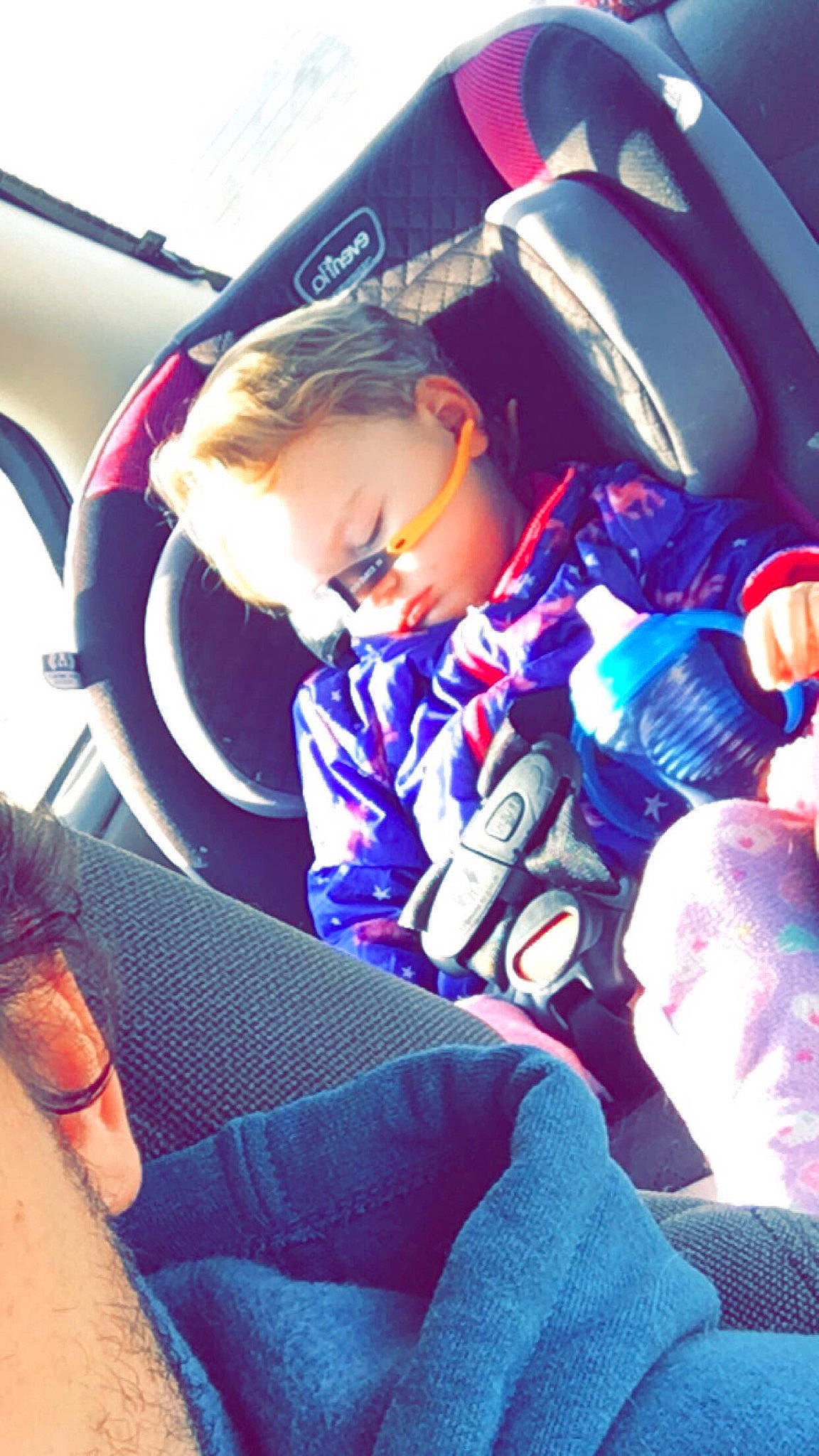 Loretta joined the competition — help win amazing prizes! auto_part, automotive_design, car_seat, car_seat_cover, comfort, cool, facial_expression, fun, head_restraint, human, interaction, lap, passenger, person, product, purple, steering_part, steering_wheel, toddler, vehicle_door