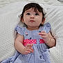 Emma joined the competition — help win amazing prizes! baby, child, infant, girl, dress, striped_clothing, pink_belt, headband, flower_accessory, earrings, bracelet, knitted_blanket, white_blanket, curious_expression, closeup, portrait, soft_lighting, indoors, cute, hands