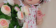 Emma joined the competition — help win amazing prizes! baby, bonnet, bracelet, child, cute, face, floral_dress, flowers, green_leaves, hand, infant, lying_down, pink, portrait, roses, skin, smiling, soft_background, white, young