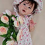 Emma joined the competition — help win amazing prizes! baby, child, floral_dress, bonnet, flowers, roses, green_leaves, cute, portrait, infant, pink, white, soft_background, bracelet, smiling, lying_down, skin, hand, face, young