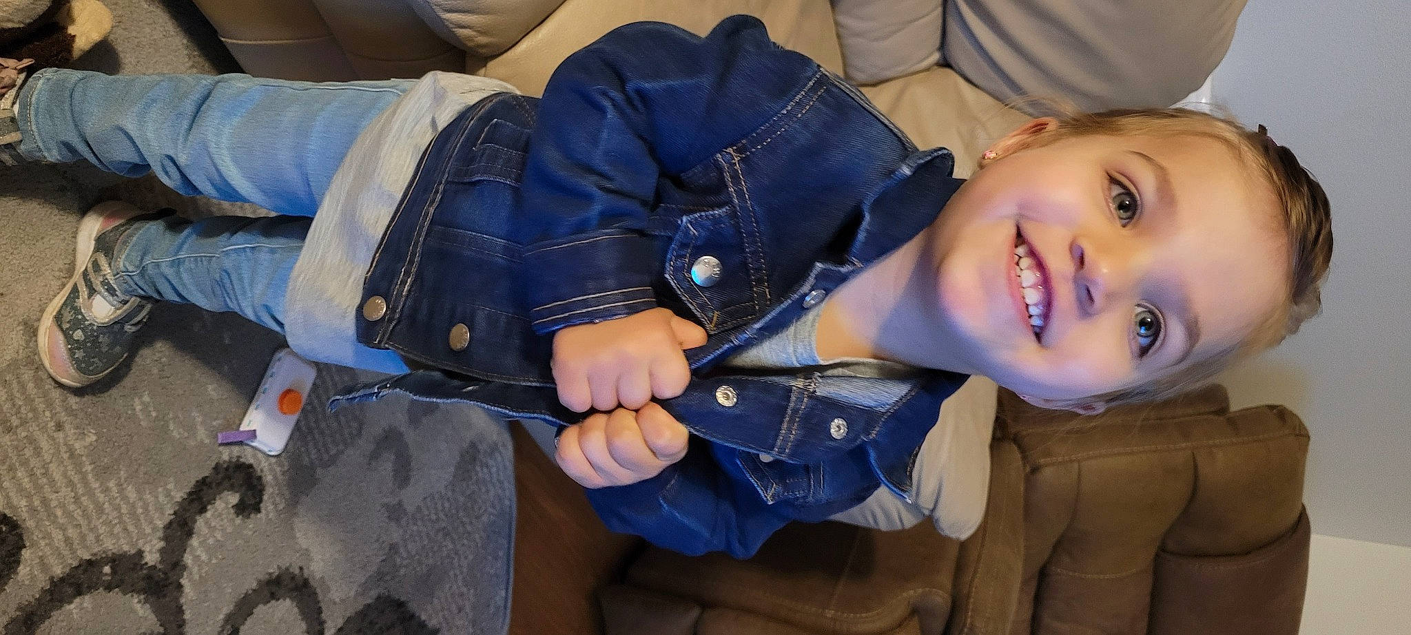 Isabella is registered to the contest to win money with this photo: child, collar, comfort, cool, denim, electric_blue, flash_photography, fun, gesture, glove, happy, jacket, joy, outerwear, person, personal_protective_equipment, plant, sitting, sleeve, smile