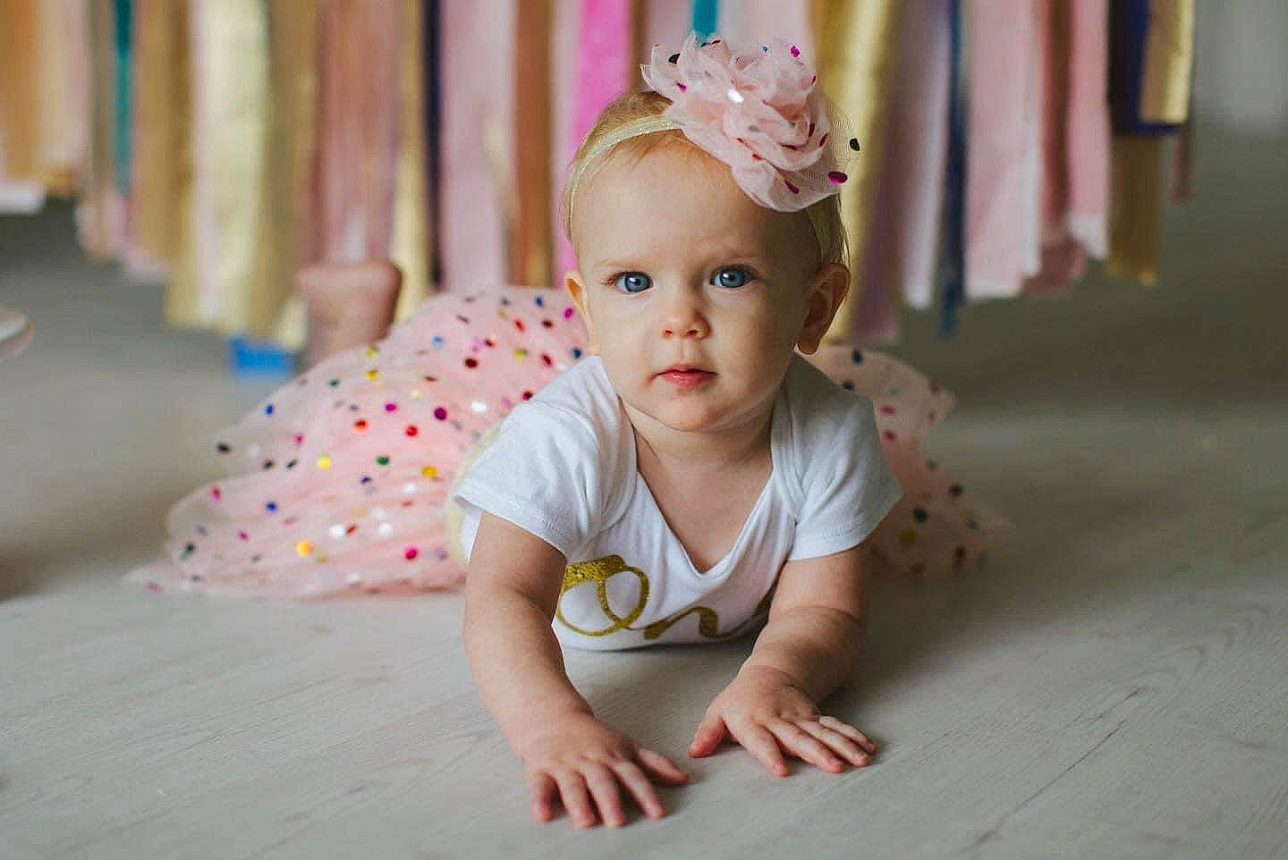 Emme joined the competition — help win amazing prizes! baby, baby_toddler_clothing, cheek, child, flash_photography, flooring, fun, grass, hair_accessory, happy, head, headgear, headpiece, iris, person, pink, plant, skin, tiara, toddler
