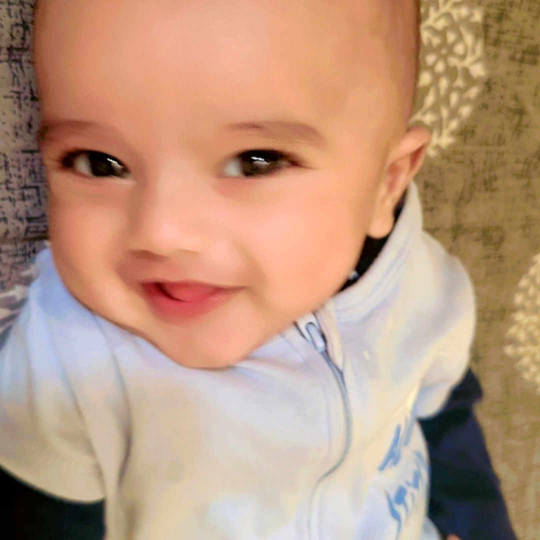 Mohammad Osman joined the competition — help win amazing prizes! baby, child, close_up, clothing, cute, eyes, face, hand, happy, head, indoors, infant, lying_down, mouth, patterned_blanket, portrait, skin, smiling, warm, zipper