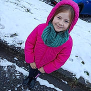 Mia a rejoint le concours — aidez-le/la à gagner de superbes lots ! boots, casual, child, clothing, cold_weather, curb, girl, happy, hood, outdoor, parked_cars, person, pink_jacket, road, scarf, seasonal, sidewalk, smiling, snow, winter
