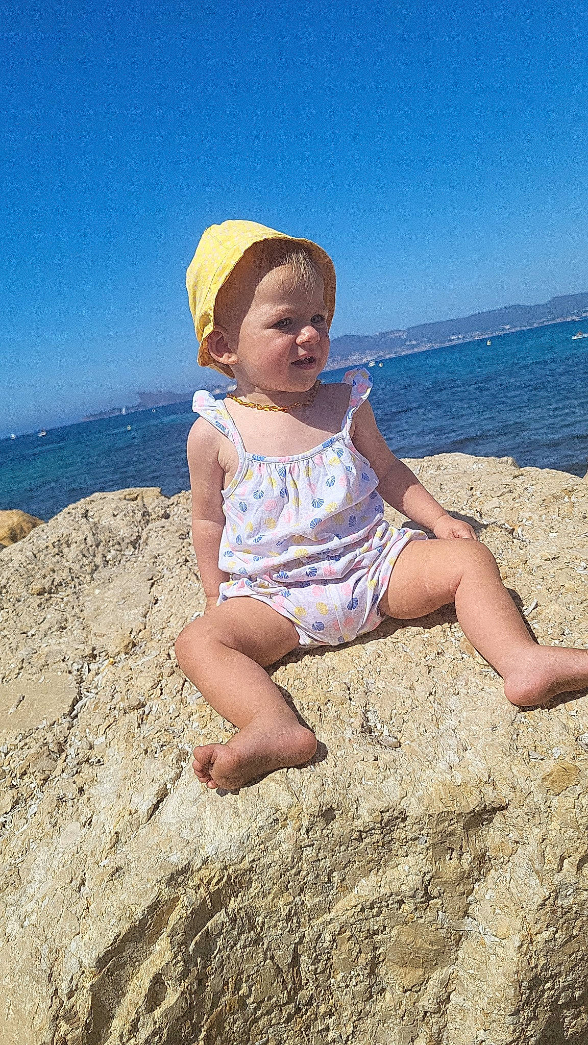 Carla participe au concours pour gagner de l'argent avec cette photo : baby_toddler_clothing, barefoot, beach, beauty, cap, coastal_and_oceanic_landforms, fun, happy, hat, horizon, leg, leisure, people_in_nature, people_on_beach, person, sand, sky, sun_hat, thigh, toddler