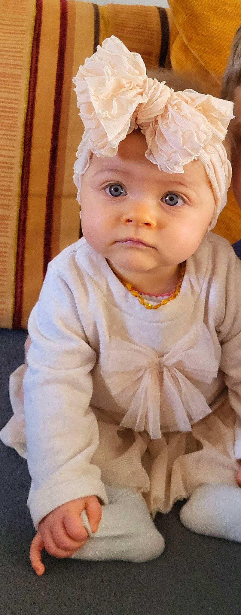 Carla participe au concours pour gagner de l'argent avec cette photo : baby, baby_toddler_clothing, cap, cheek, child, collar, costume_hat, dress, fashion_accessory, happy, headpiece, headwear, iris, jewellery, lip, outerwear, person, pink, sleeve, textile