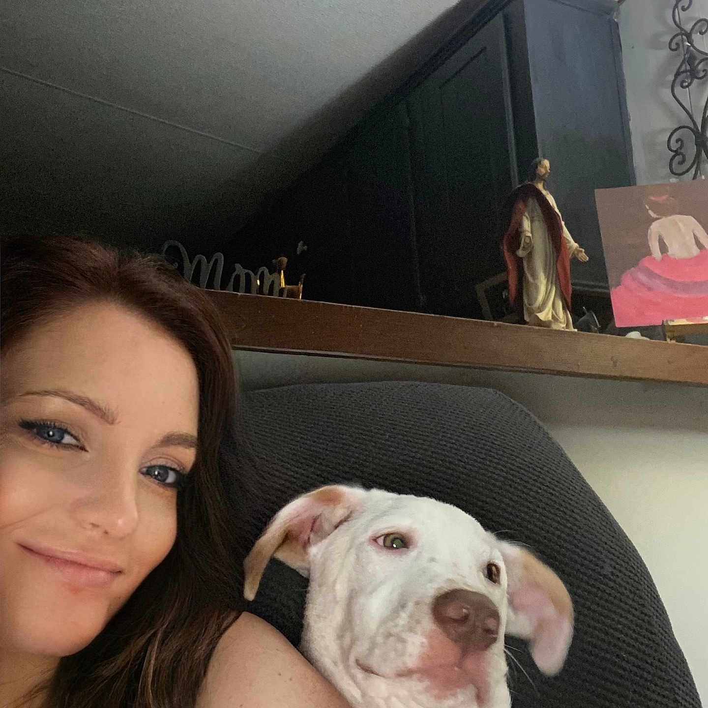 Milo joined the competition — help win amazing prizes! blue_eyes, brown_hair, casual, chair, companion, cozy, dog, friendly, home, indoor, painting, pet, portrait, relaxing, selfie, shelf, smile, statue, white_dog, woman