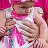 adult, baby, child, closeup, curious, cute, dress, face, hands, head, headband, human, indoor, infant, person, pink_clothing, portrait, sitting, skin, supporting