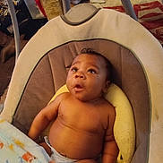 Jabari is registered to the contest to win money with this photo: baby, infant, child, blanket, diaper, baby_seat, indoor, cushion, curious, expression, person, skin, head, arm, torso, furniture, comfort, home, warm, seated