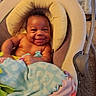 Jabari is registered to the contest to win money with this photo: baby, smiling, blanket, infant, baby_seat, cushion, indoor, happy, child, person, cute, colorful, cozy, furniture, portrait, young, resting, comfort, skin, head