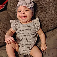Kierra is registered to the contest to win money with this photo: baby, smiling, headband, flower, onesie, clothing, happy, infant, cute, sitting, blanket, soft, texture, indoors, portrait, child, skin, sock, expression, comfort