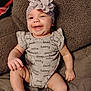 baby, smiling, headband, flower, onesie, clothing, happy, infant, cute, sitting, blanket, soft, texture, indoors, portrait, child, skin, sock, expression, comfort