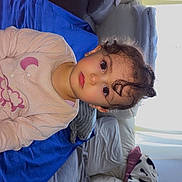 Manël a rejoint le concours — aidez-le/la à gagner de superbes lots ! blanket, child, couch, cozy, curious, curly_hair, expression, face, furniture, home, indoor, living_room, pillows, pink_clothing, portrait, sitting, soft_light, toddler, window_light, young_child