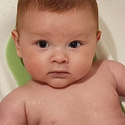 Takoda is registered to the contest to win money with this photo: baby, infant, face, skin, wet, bath, bathtub, child, water, young, expression, looking, curious, naked, seat, head, arms, human, indoors, portrait