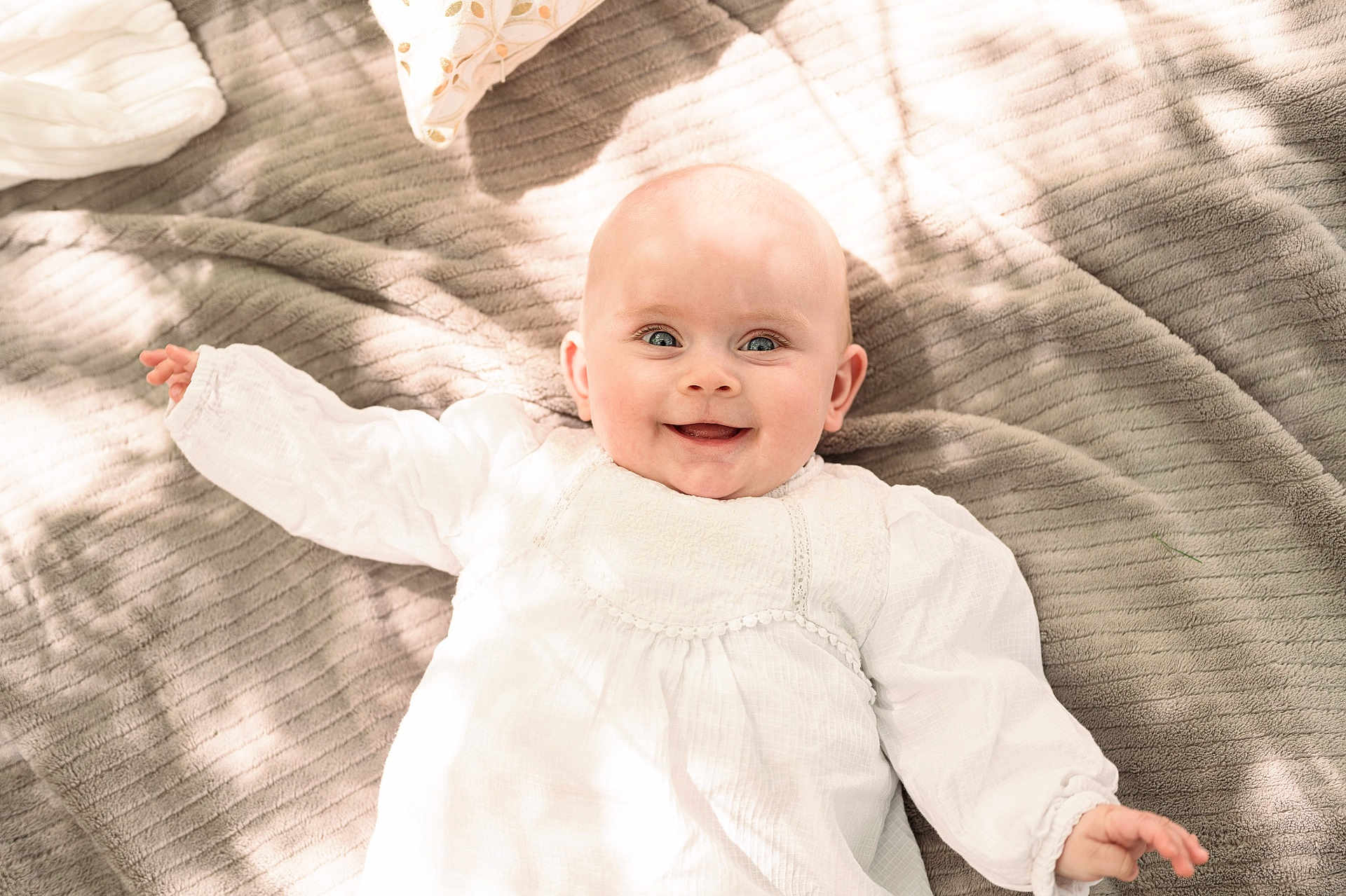 éléonore participe au concours pour gagner de l'argent avec cette photo : baby, infant, smile, white_clothing, blanket, soft_texture, lying_down, happy, portrait, child, cute, indoors, natural_light, face, small_hand, head, cheerful, young_child, fabric, cozy