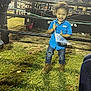 Kyzer is registered to the contest to win money with this photo: child, toddler, blue_shirt, jeans, boots, grass, flag, outdoor, night, fence, people, event, smiling, happy, curly_hair, standing, clothing, person, casual, celebration