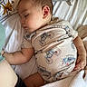 baby, bed, blanket, car_print, child, cute, floral_pattern, hand, head, indoors, infant, motorcycle_print, onesie, peaceful, person, pillow, resting, skin, sleeping, soft_lighting